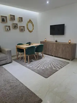 a living room with a table and a tv at Chez Dar safaa in Marrakech