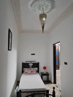 a bedroom with a bed and a chandelier on the ceiling at Riad Anisse in Marrakech