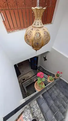 a large vase hanging from a ceiling with potted plants at Riad Anisse in Marrakech