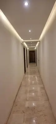 a hallway with white walls and a tile floor at Nour 5 marrakech in Marrakech