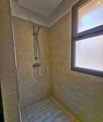 a shower in a bathroom with a window at Magnifique appartement spacieux avec une belle terrasse ensoleillée in Marrakech