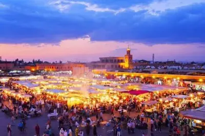 a crowd of people walking around a market at night at Magnifique appartement spacieux avec une belle terrasse ensoleillée in Marrakech
