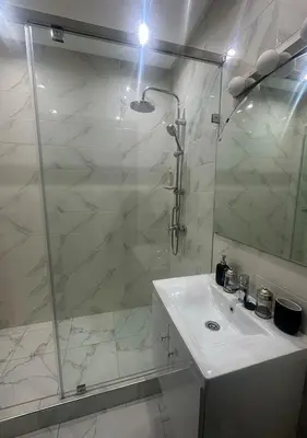 a white bathroom with a shower and a sink at Appartement agréable en plein coeur de Marrakech pour 2 à 4 Personnes in Marrakech