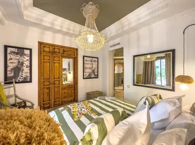 a bedroom with a bed and a chandelier at Maison Maria Palmeraie in Marrakech
