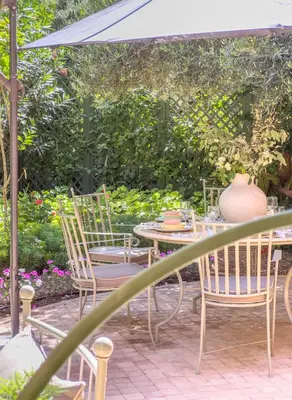 a patio with a table and chairs under an umbrella at Maison Maria Palmeraie in Marrakech