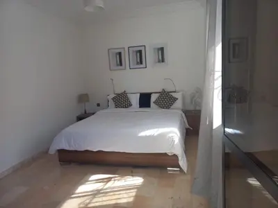 a bedroom with a white bed with pillows on it at Belle Vue in Marrakech
