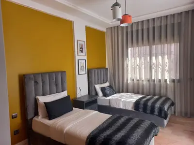 a bedroom with two beds and a window at Belle Vue in Marrakech