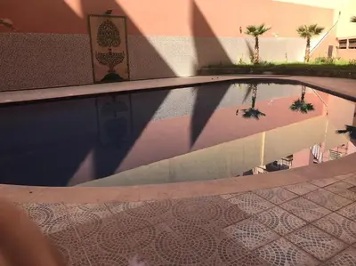 a reflection of a swimming pool in a building at Belle Vue in Marrakech