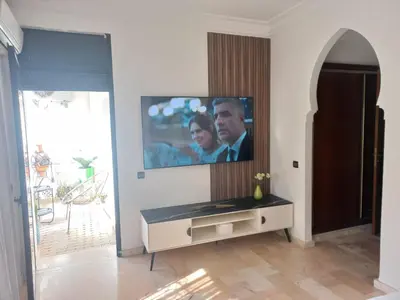 a living room with a flat screen tv on a wall at Belle Vue in Marrakech