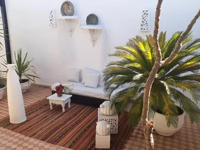 a living room with a couch and a palm tree at DUPLEX MEDINA AVEC TERRASSE in Marrakech