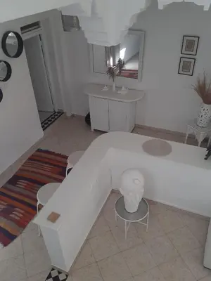 a living room with a bed and a table and chairs at DUPLEX MEDINA AVEC TERRASSE in Marrakech