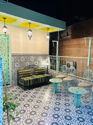 a room with a bed and tables and chairs at Maison Cascada in Marrakech