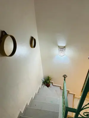 a staircase with a potted plant and a light on the wall at Maison Cascada in Marrakech