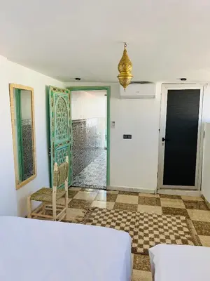 a room with a bed and a door and a chair at Maison Cascada in Marrakech