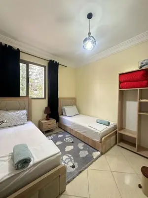 a bedroom with two beds and a rug at Charming Room Near Marrakech Airport in Marrakech