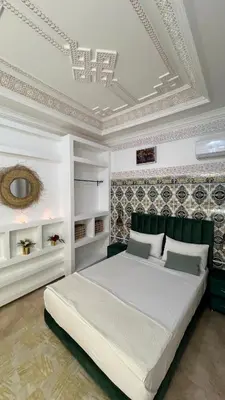 a bedroom with a large white bed with a ceiling at Riad dar Benaarab 2 aéroport 800 M in Marrakech