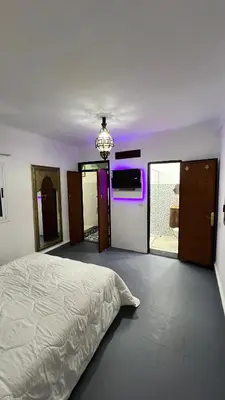 a bedroom with a bed and a purple light at Riad dar Benaarab 2 aéroport 800 M in Marrakech