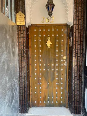 a large wooden door with a star on it at Riad dar Benaarab 2 aéroport 800 M in Marrakech