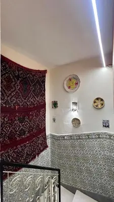 a room with plates on the wall and a staircase at Riad dar Benaarab 2 aéroport 800 M in Marrakech