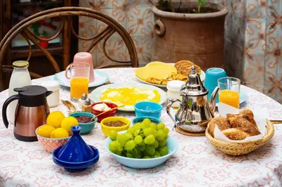 a table with breakfast foods and oranges and juice at Riad Taghia in Marrakech