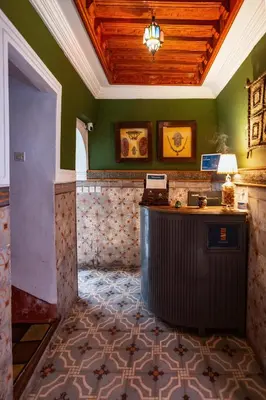 a lobby with green walls and a desk in a room at Riad Taghia in Marrakech