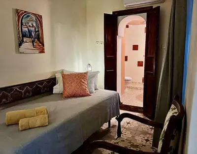 a bedroom with a bed and a door to a bathroom at Riad Taghia in Marrakech