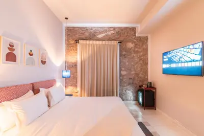 a bedroom with a white bed and a flat screen tv at JEMAA EL FNA Suites & Spa in Marrakech