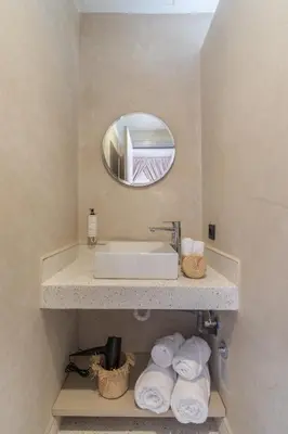 a bathroom with a sink and a mirror and towels at JEMAA EL FNA Suites & Spa in Marrakech