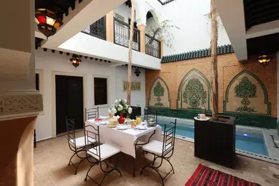 a dining room with a table and chairs and a pool at Riad 22 - L'Etoile d'Orient in Marrakech