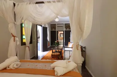 a bedroom with a bed with white curtains at Riad 22 - L'Etoile d'Orient in Marrakech