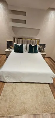 a bedroom with a large white bed with blue pillows at Appartement moderne, confort avec piscine et clim in Marrakech
