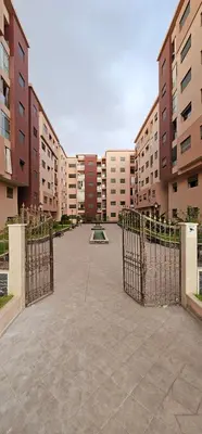 an empty courtyard with a gate in a building at Appartement moderne, confort avec piscine et clim in Marrakech