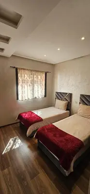 a bedroom with two beds and a window at Appartement moderne, confort avec piscine et clim in Marrakech