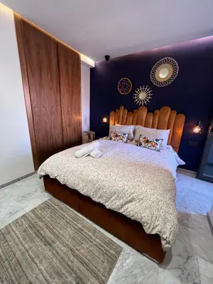 a bedroom with a large bed with a wooden headboard at Luxury apartment in center Of Marrakech City in Marrakech