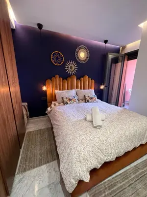a bedroom with a large bed with a blue wall at Luxury apartment in center Of Marrakech City in Marrakech