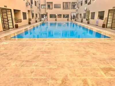 a large swimming pool with blue water in a building at Cozy&Elegant apartment/pool/city center/Gueliz in Marrakech