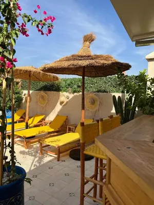 a group of chairs and an umbrella on a patio at Riad Les Gazelles D'Orient Marrakech in Marrakech