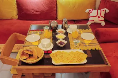 a coffee table with a tray of food on a couch at Riad Les Gazelles D'Orient Marrakech in Marrakech