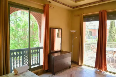 a bedroom with a large window with a balcony at Palmeraie Stay - Pool & Lake in Marrakech