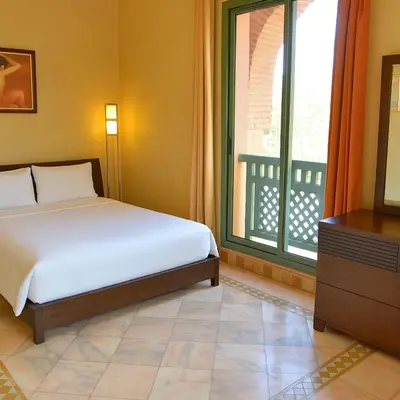 a bedroom with a bed and a window and a television at Palmeraie Stay - Pool & Lake in Marrakech