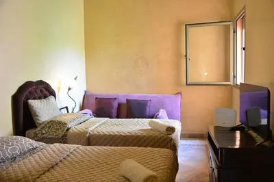a bedroom with two beds and a mirror on the wall at Palmeraie Stay - Pool & Lake in Marrakech