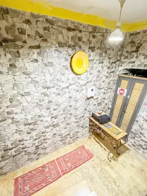 a room with a stone wall with a bench and a clock at Sun Hostel in Marrakech