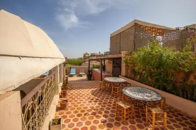 a patio with two tables and chairs on a balcony at Riad en Exlusivité à 5min de la place jamaa el fna in Marrakech