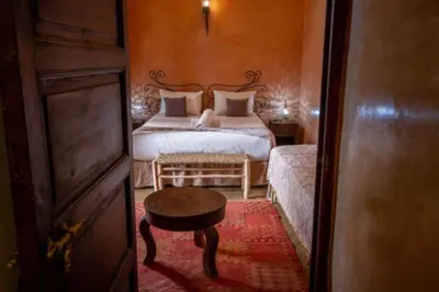 a bedroom with a bed and a table in a room at Riad en Exlusivité à 5min de la place jamaa el fna in Marrakech