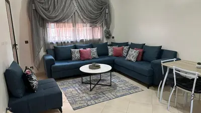 a living room with a blue couch and a table at OASIS PALM MARRAKECH APARTMENT- 5 Piscines in Marrakech