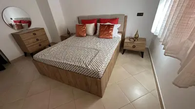 a bedroom with a bed with red pillows and a mirror at OASIS PALM MARRAKECH APARTMENT- 5 Piscines in Marrakech