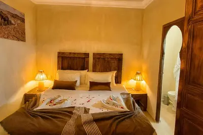 a bedroom with a large bed with two lamps at Riad Belikoss Pool & SPA in Marrakech