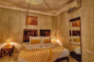 a bedroom with two beds and two lamps in it at Riad Belikoss Pool & SPA in Marrakech