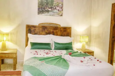 a bedroom with a large bed with green and white sheets at Riad Belikoss Pool & SPA in Marrakech