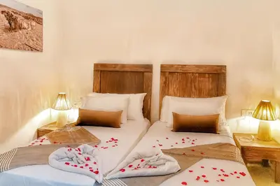 two twin beds in a room with two lamps at Riad Belikoss Pool & SPA in Marrakech